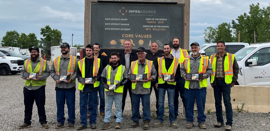 A group of InfraSource people standing with their Quanta commitment coins.
